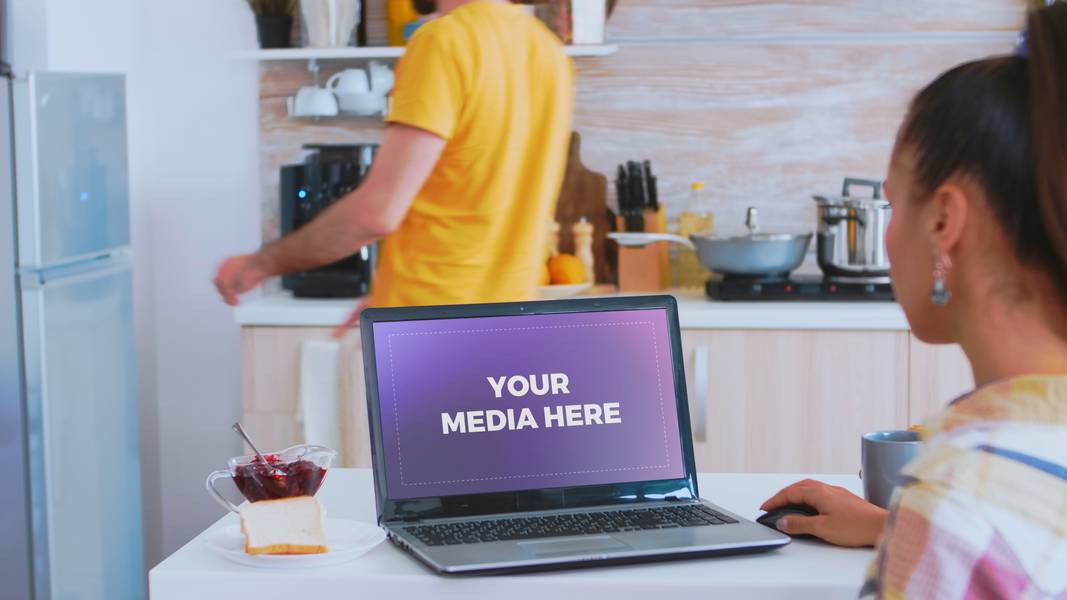 Woman in kitchen on laptop