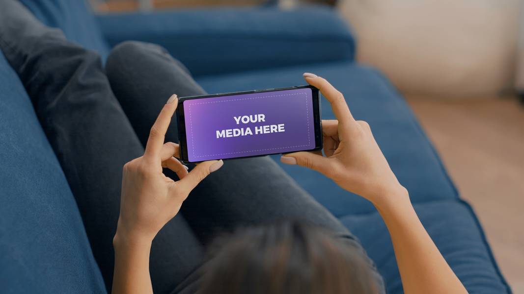 Woman holding phone on sofa landscape