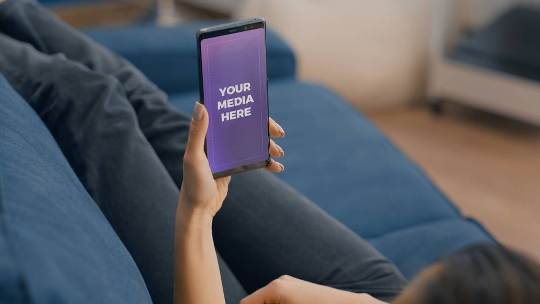 Woman holding phone on sofa